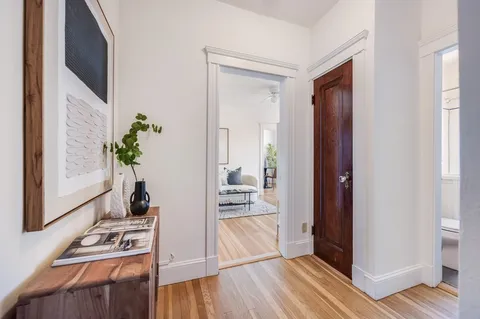 a hallway with wooden floor and front door