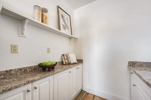 a kitchen with stainless steel appliances granite countertop a sink a stove and a wooden floors