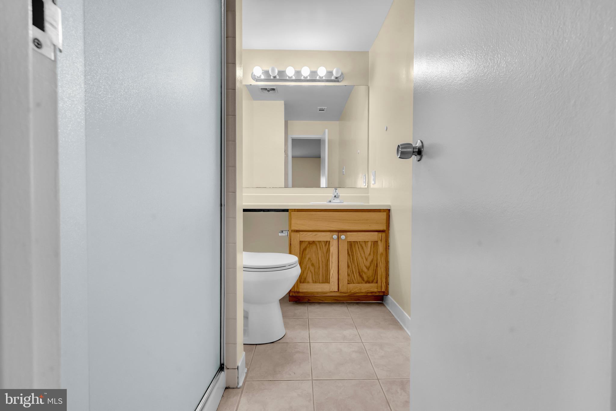 9920 Walker House Road, Unit 5 Gaithersburg, MD 20886 - Photo 13 of 24 a view of a bathroom with a toilet sink and a mirror