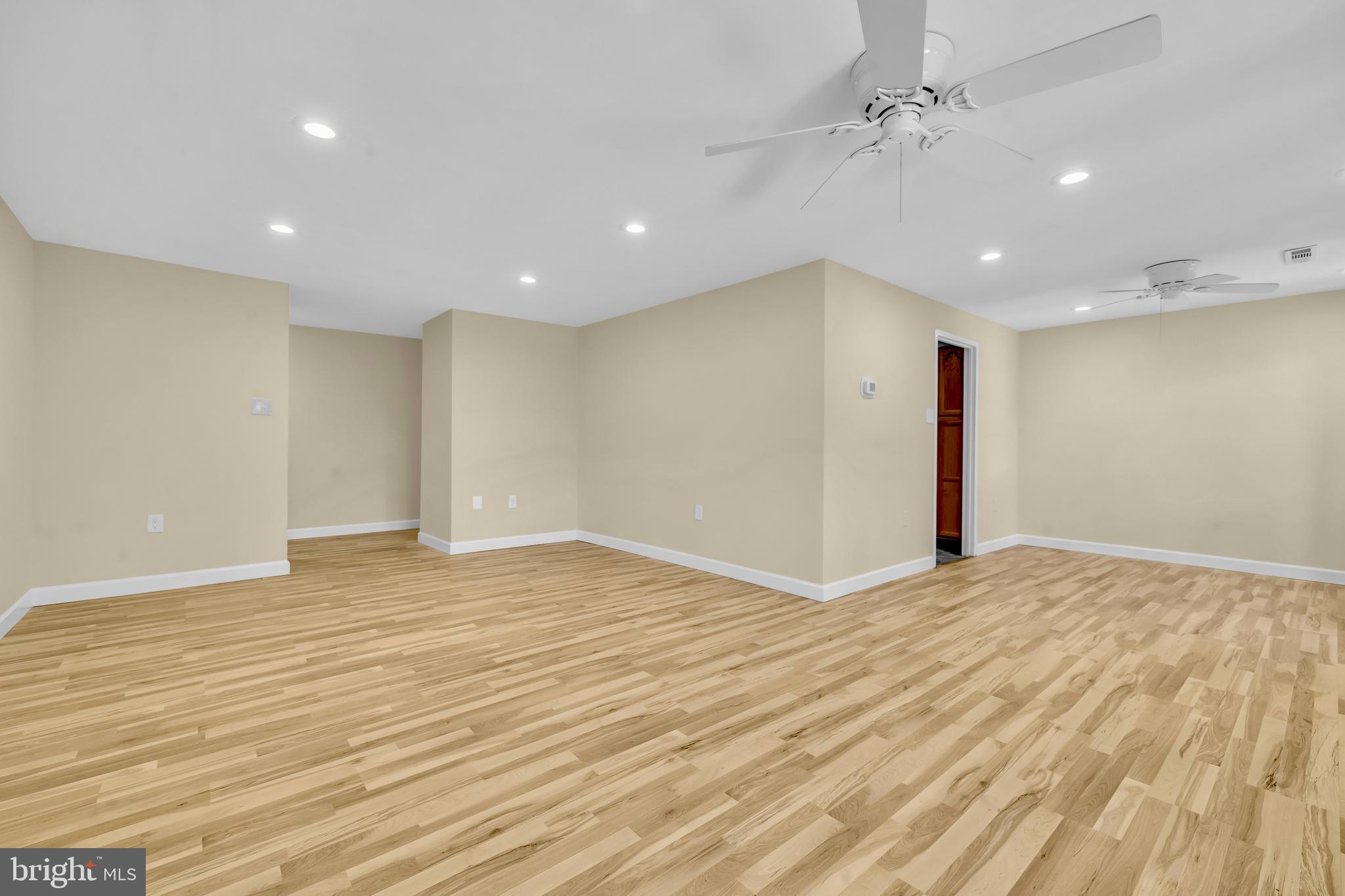 9920 Walker House Road, Unit 5 Gaithersburg, MD 20886 - Photo 4 of 24 a view of an empty room with wooden floor and a ceiling fan
