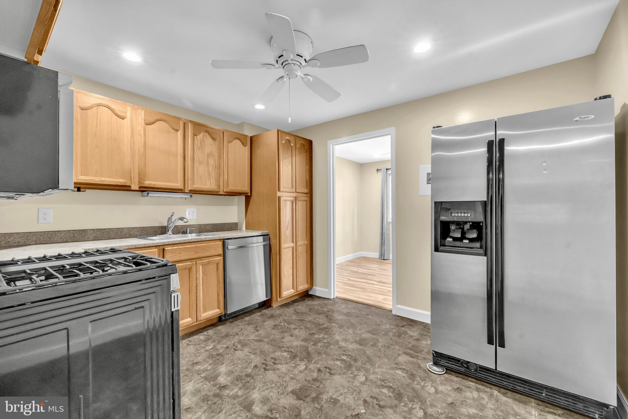 9920 Walker House Road, Unit 5 Gaithersburg, MD 20886 - Photo 6 of 24 a kitchen with stainless steel appliances granite countertop a refrigerator a sink and white cabinets