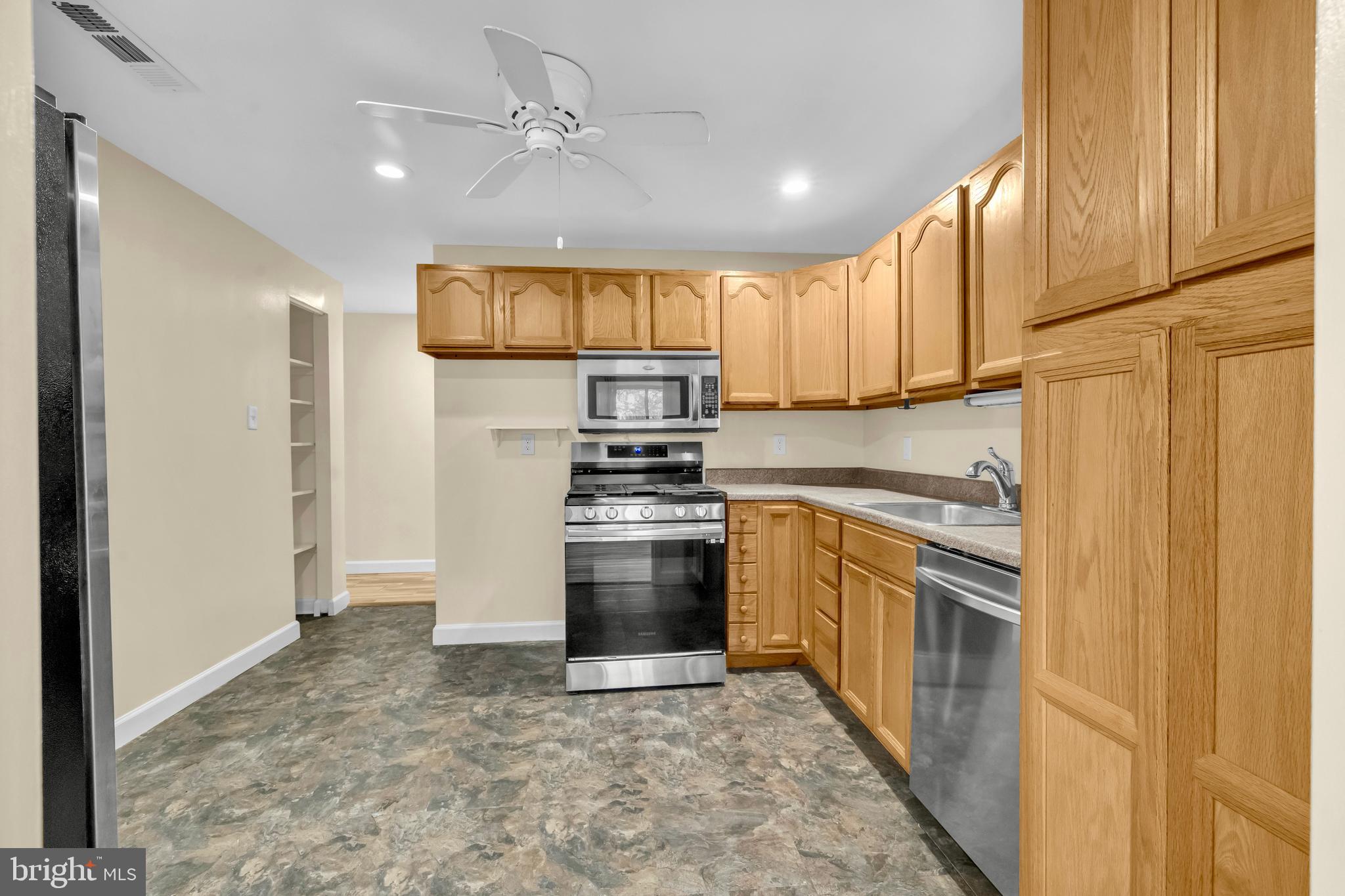 9920 Walker House Road, Unit 5 Gaithersburg, MD 20886 - Photo 7 of 24 a kitchen with stainless steel appliances granite countertop a refrigerator a stove and a sink with cabinets
