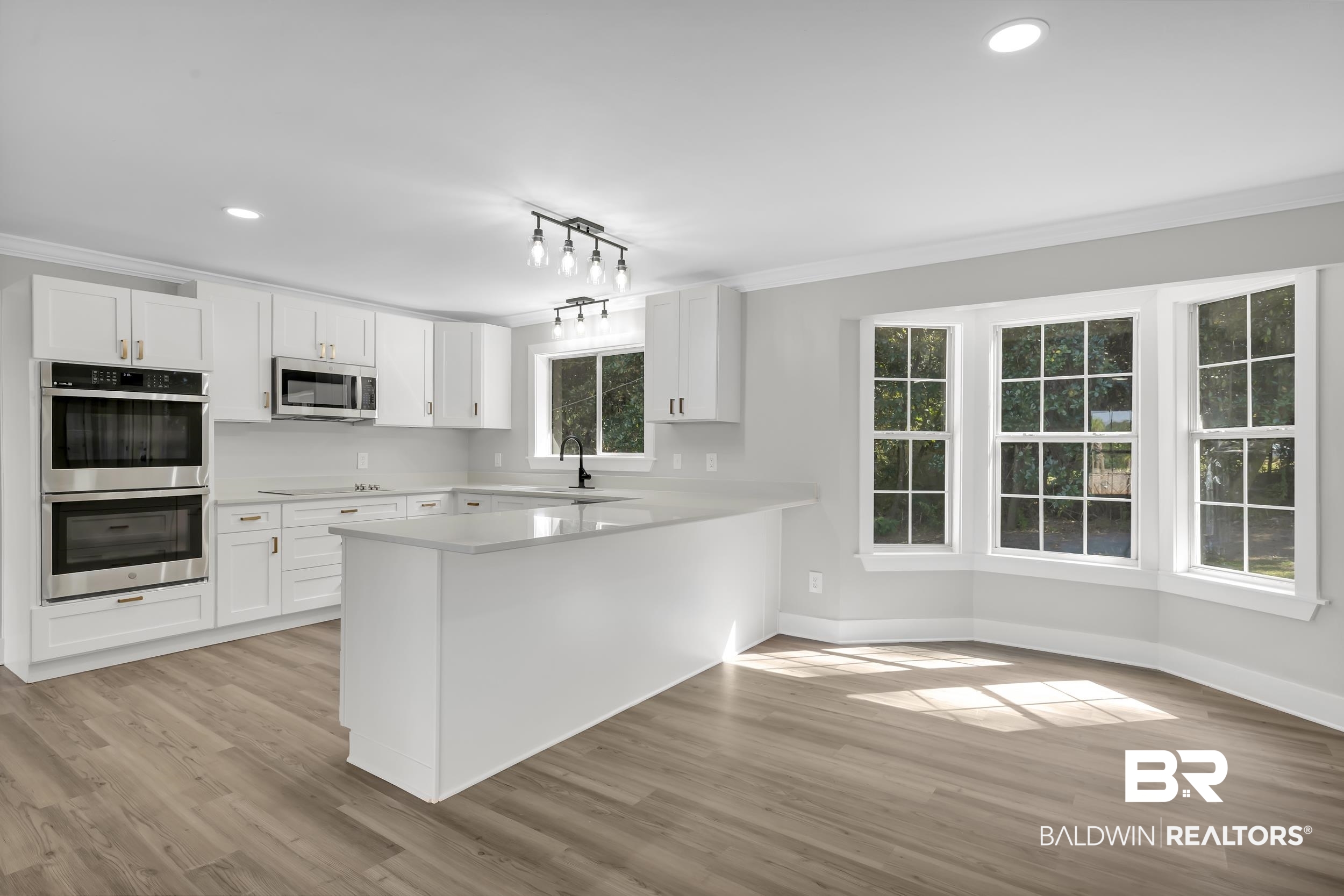 8351 Theodore Dawes Road Theodore, AL 36582 - Photo 12 of 46 Kitchen with stainless steel appliances, white cabinetry, a peninsula, light wood finished floors, and recessed lighting
