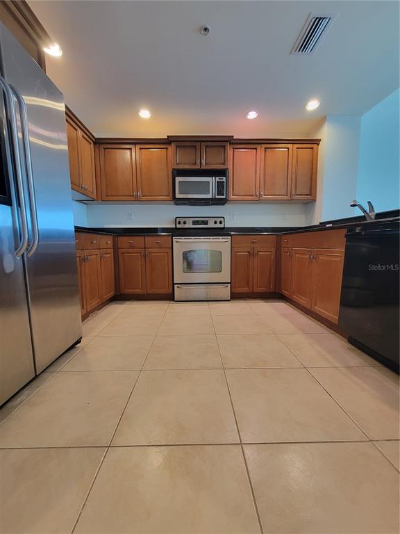 1771 Ringling Boulevard, Unit 902 Sarasota, FL 34236 - Photo 12 of 60 a kitchen with stainless steel appliances granite countertop a refrigerator and a stove