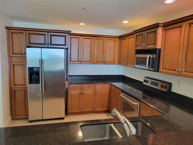 a kitchen with stainless steel appliances granite countertop a refrigerator and a sink