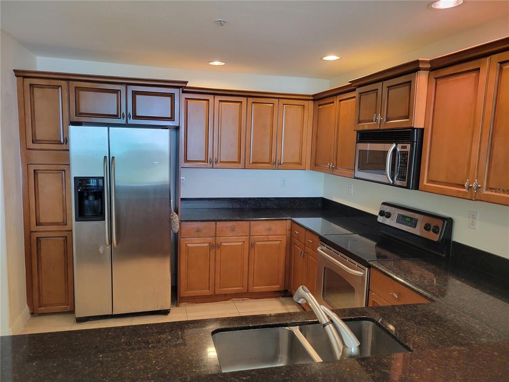 1771 Ringling Boulevard, Unit 902 Sarasota, FL 34236 - Photo 13 of 60 a kitchen with stainless steel appliances granite countertop a refrigerator and a sink