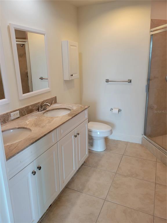 1771 Ringling Boulevard, Unit 902 Sarasota, FL 34236 - Photo 35 of 60 a spacious bathroom with a granite countertop sink a toilet and a mirror