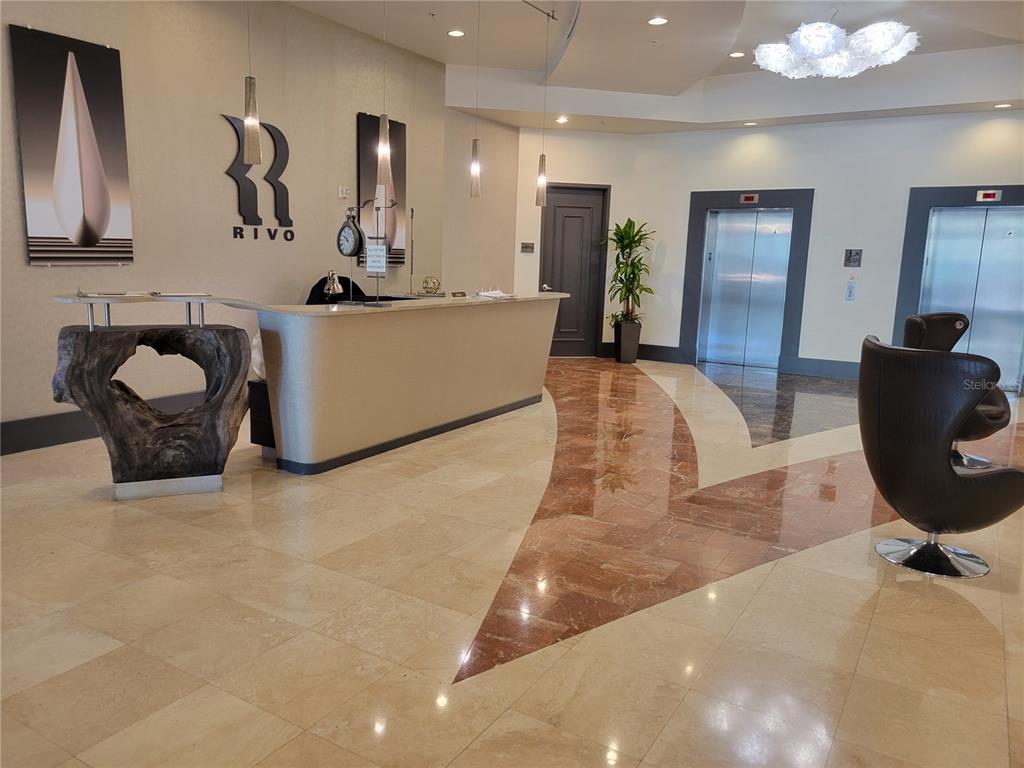 1771 Ringling Boulevard, Unit 902 Sarasota, FL 34236 - Photo 4 of 60 a living room with furniture a mirror and lamp