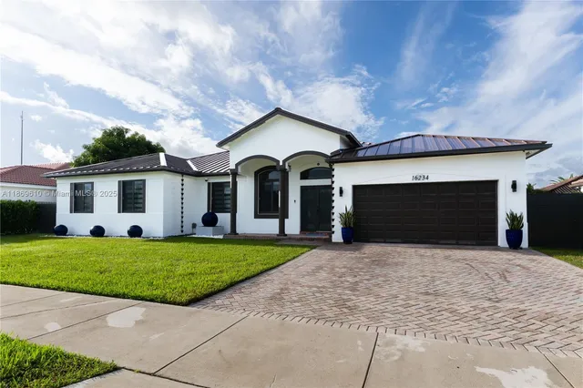 a front view of a house with a garden and yard