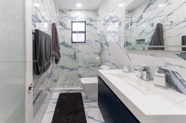 a bathroom with a sink vanity granite and a shower