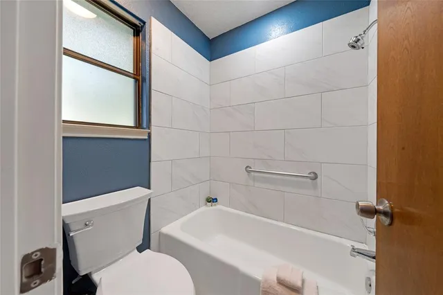 a white toilet sitting next to a bath tub