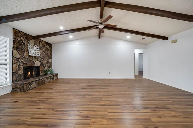 a view of a room with wooden floor and a fireplace