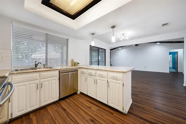 a kitchen with a white cabinets and chandelier