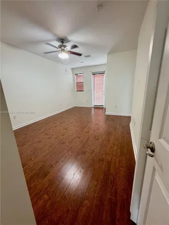 a view of empty room with wooden floor