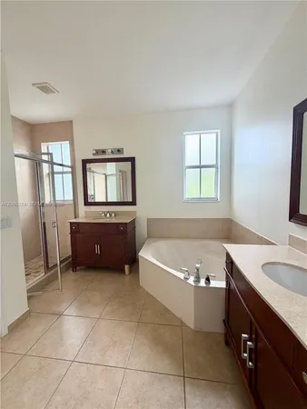 a bathroom with a tub sink and mirror