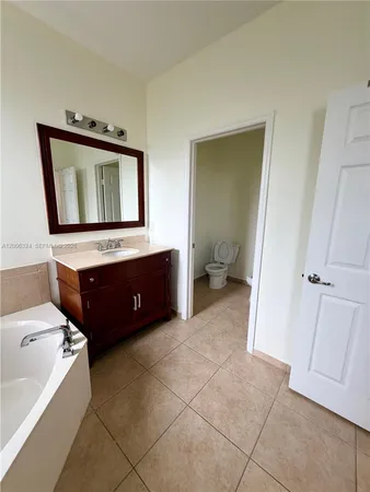 a bathroom with a toilet a mirror and vanity