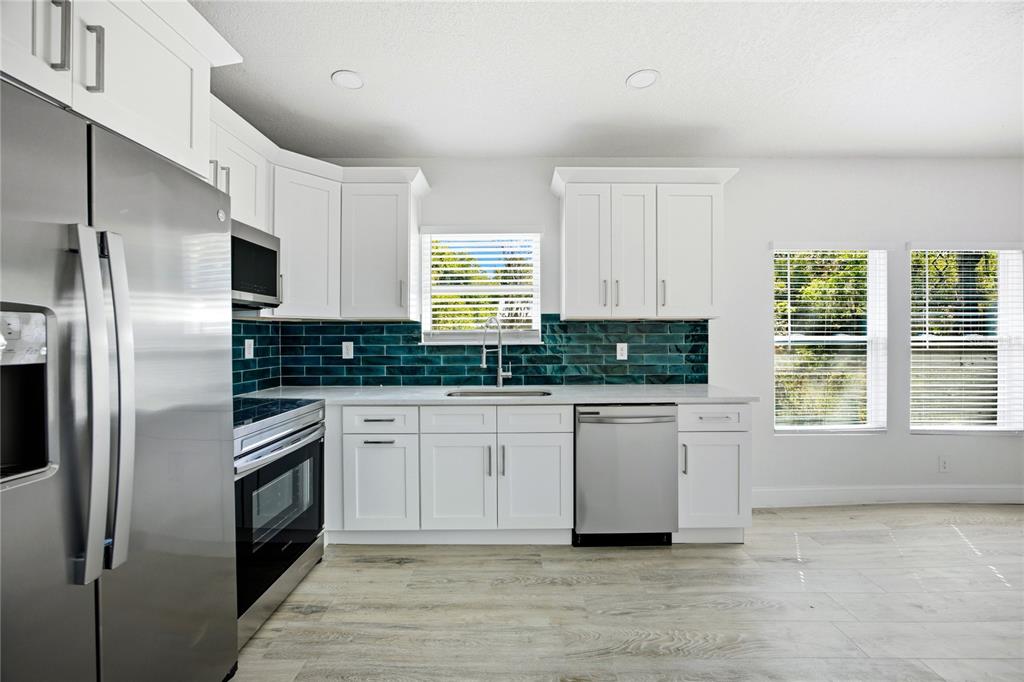 418 Northwest 3rd Avenue Gainesville, FL 32601 - Photo 17 of 31 a kitchen with stainless steel appliances granite countertop a refrigerator a stove and a sink
