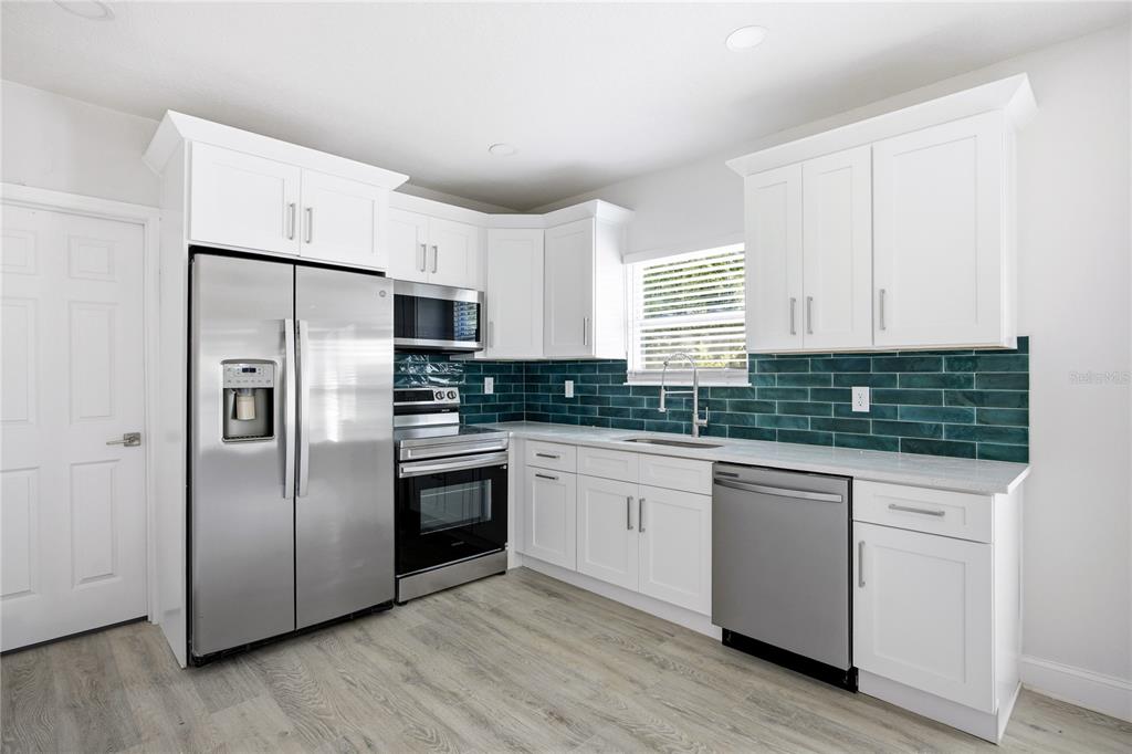 418 Northwest 3rd Avenue Gainesville, FL 32601 - Photo 19 of 31 a kitchen with stainless steel appliances a refrigerator sink and microwave