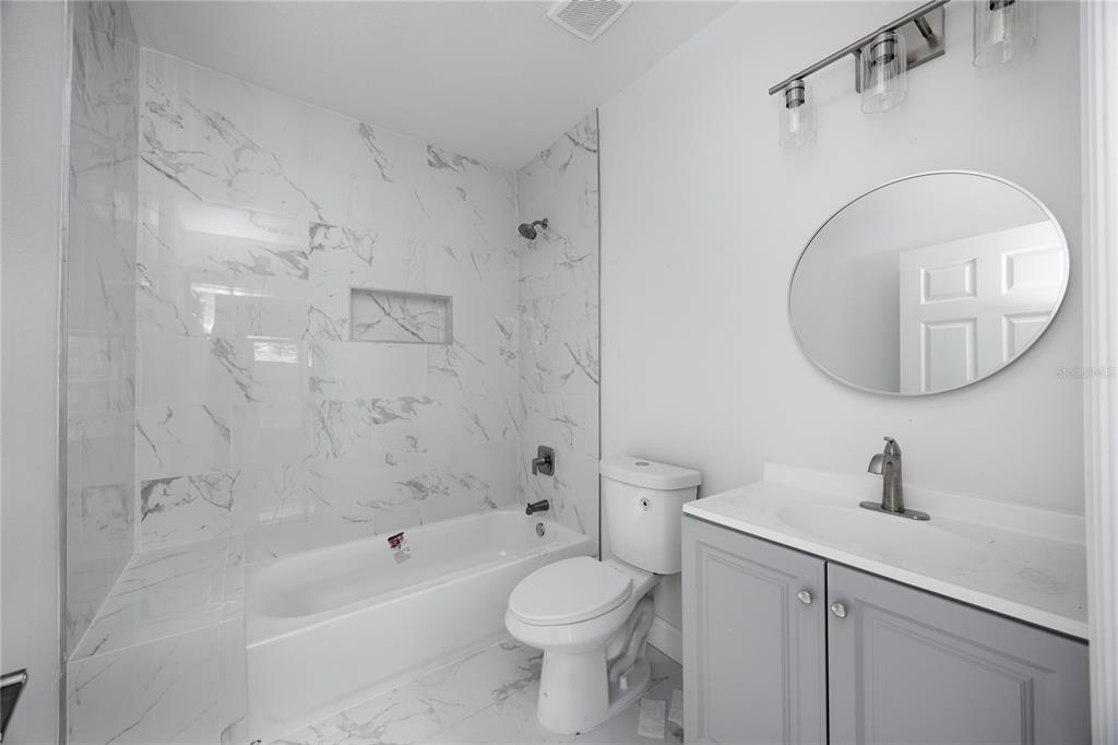 418 Northwest 3rd Avenue Gainesville, FL 32601 - Photo 24 of 31 a bathroom with a toilet a sink a mirror and bathtub