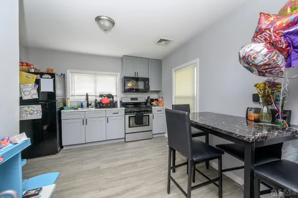 a kitchen with a table chairs refrigerator and microwave