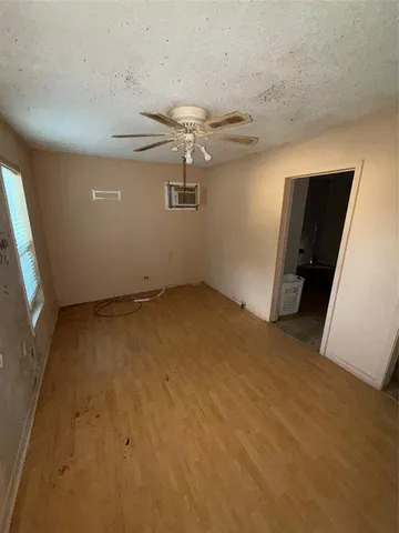 en empty room with windows and ceiling fan