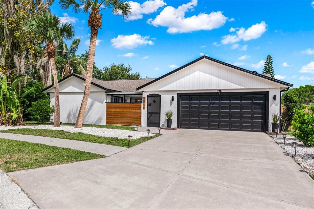 2911 Woodpine Court Sarasota, FL 34231 - Photo 2 of 88 a front view of a house with a yard and garage