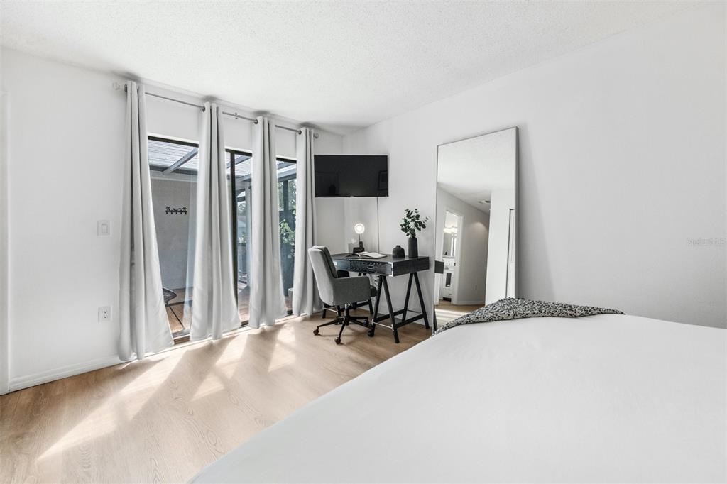 2911 Woodpine Court Sarasota, FL 34231 - Photo 25 of 88 a room with a bed a chair and potted plant with the walls