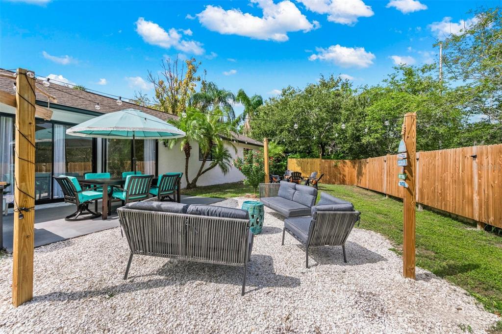 2911 Woodpine Court Sarasota, FL 34231 - Photo 49 of 88 a backyard of a house with table and chairs