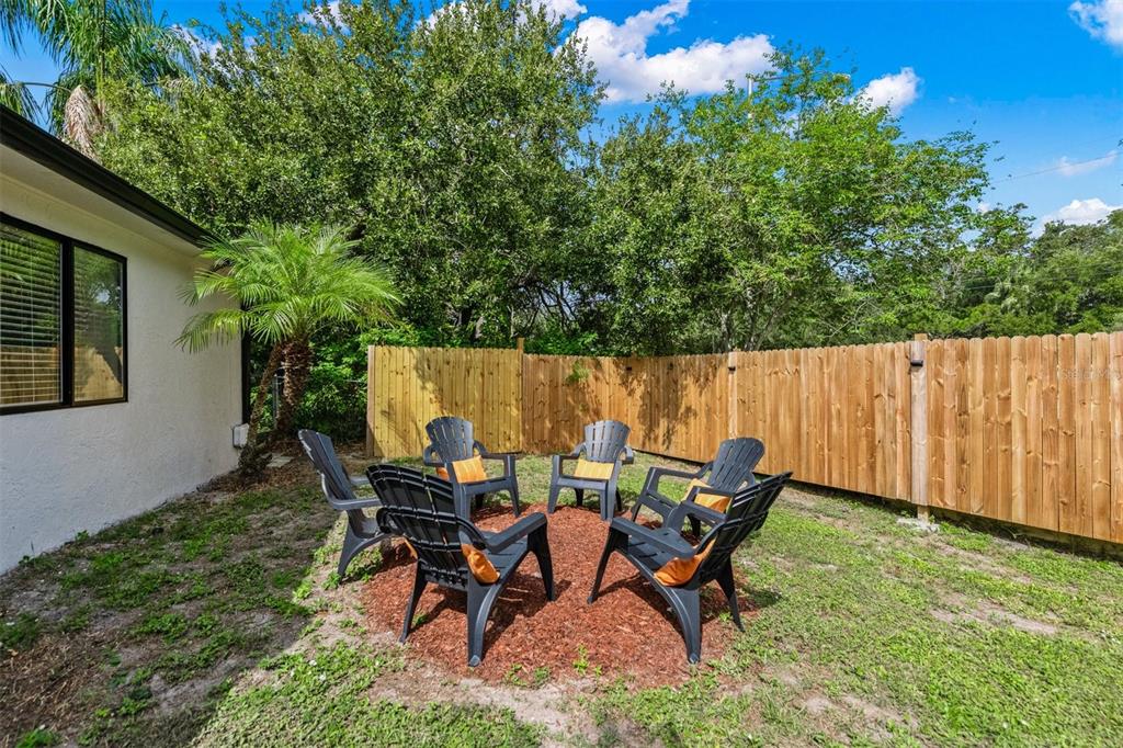 2911 Woodpine Court Sarasota, FL 34231 - Photo 50 of 88 a backyard of a house with table and chairs