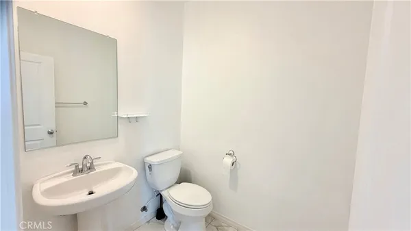 a bathroom with a sink toilet and a mirror