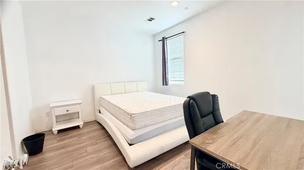 a view of a bedroom with furniture and wooden floor
