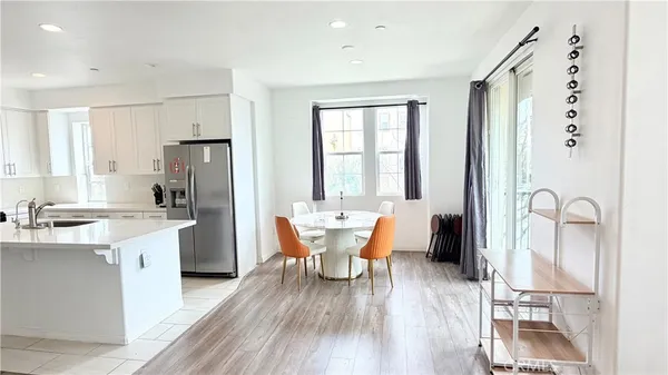 a dining room with stainless steel appliances a table and chairs