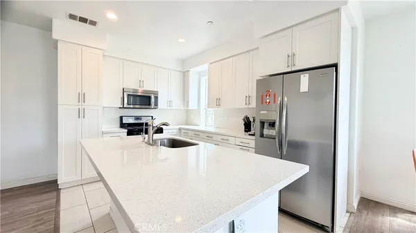 a kitchen with stainless steel appliances a refrigerator sink stove microwave and cabinets