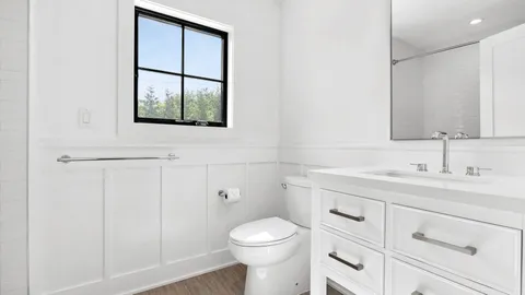 a bathroom with a toilet a sink a vanity and mirror