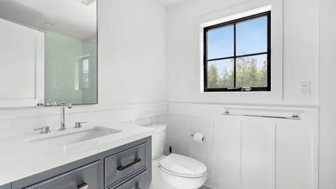 a bathroom with a toilet a sink a vanity and mirror