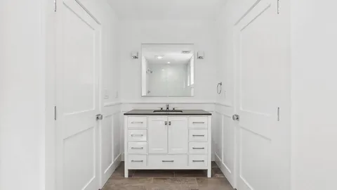 a bathroom with a granite countertop sink and a mirror