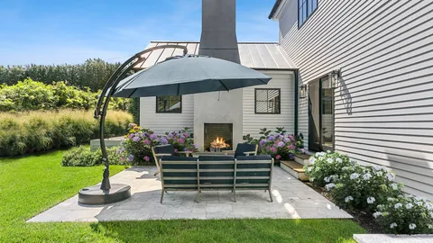 a front view of a house with a garden and patio