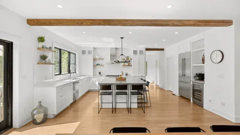 a large white kitchen with a large window
