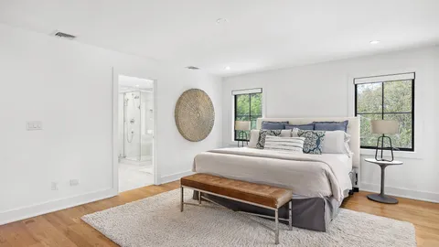 a bedroom with a bed a window and dresser