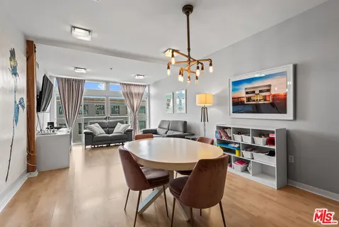 a dining room with furniture a chandelier and wooden floor