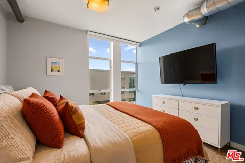 a bedroom with a bed and a flat screen tv