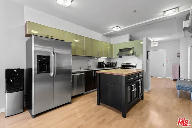 a kitchen with stainless steel appliances granite countertop a stove a refrigerator and a sink