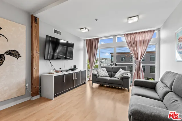 a living room with furniture a flat screen tv and a large window