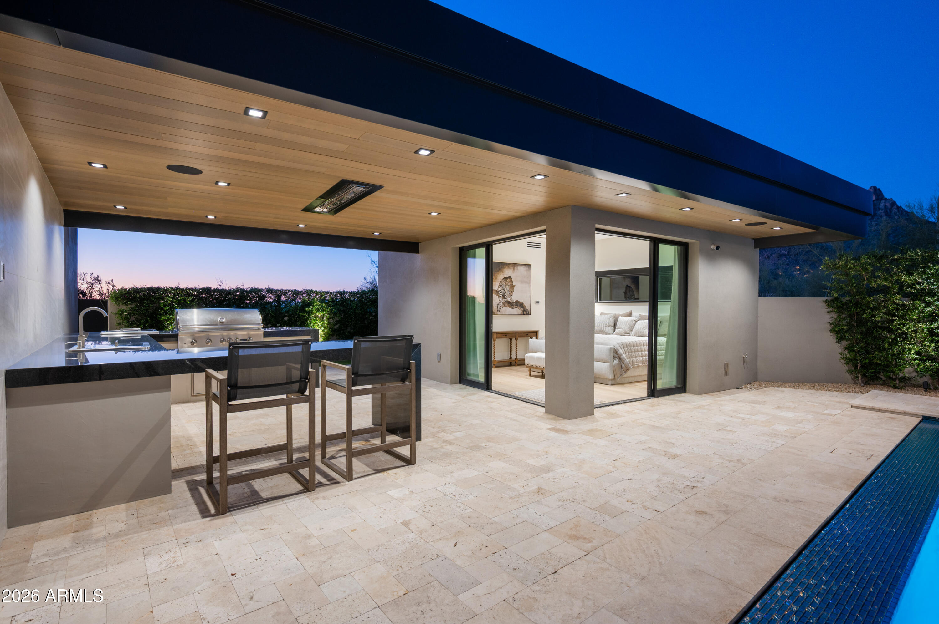 10040 East Happy Valley Road, Unit 13 Scottsdale, AZ 85255 - Photo 43 of 55 a view of a patio with dining table and chairs under an umbrella with a fireplace