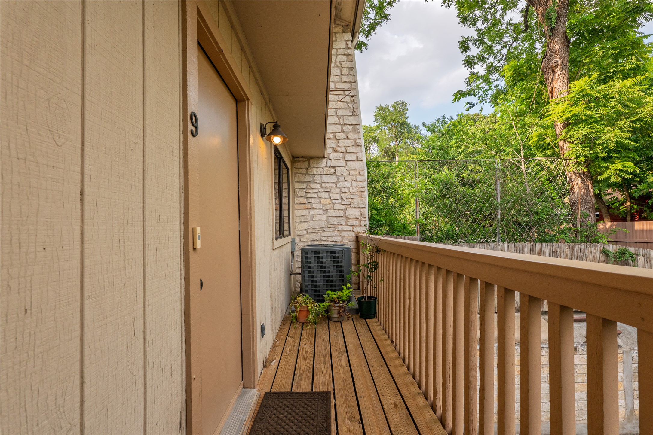 2500 Enfield Road, Unit 9 Austin, TX 78703 - Photo 23 of 26 Wood-finish exterior siding balcony overlooking the garage/parking area.
