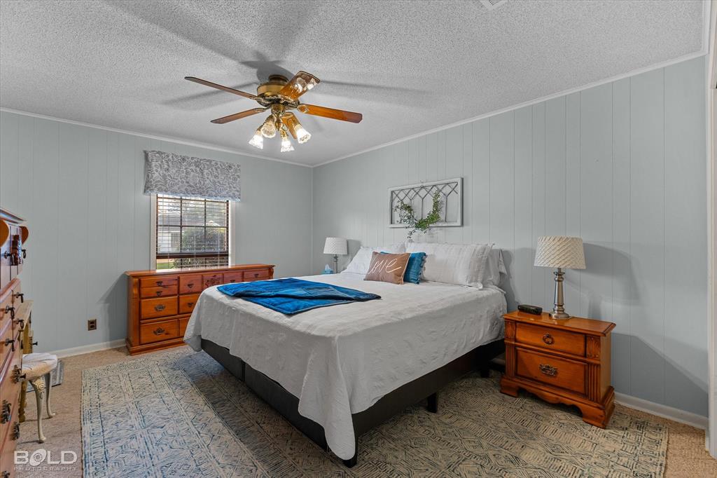 202 Butler Street Springhill, LA 71075 - Photo 28 of 38 a bedroom with a bed and a chandelier