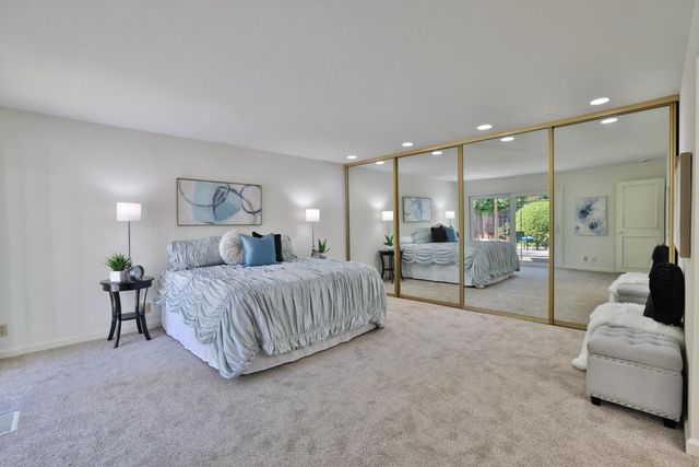 a bedroom with a large bed and a chandelier