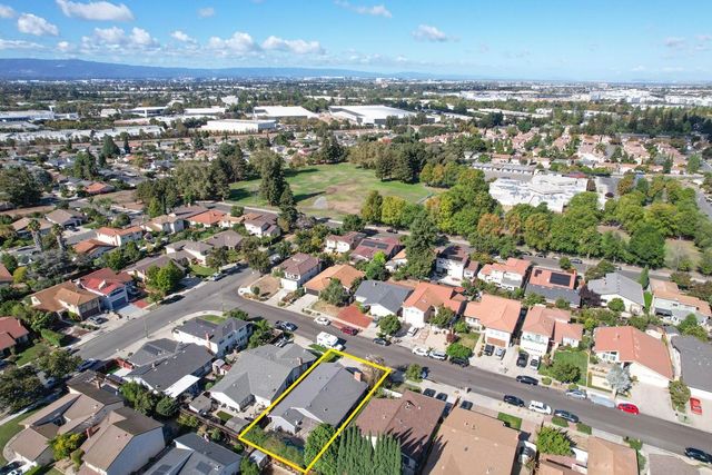an aerial view of a city with lots of residential buildings and ocean view in back