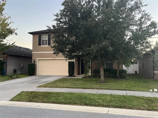 a front view of a house with a yard and a garage