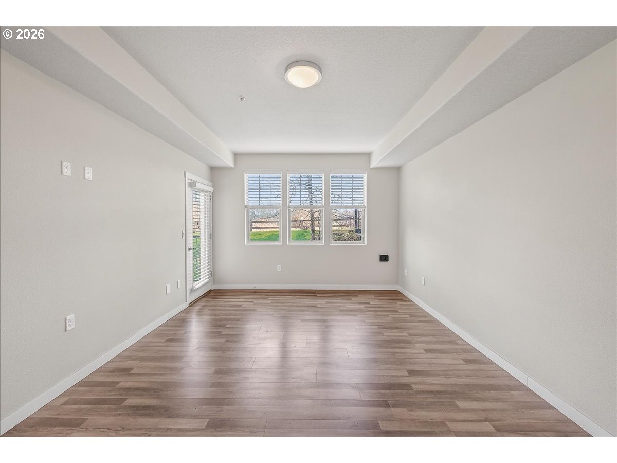 16401 Northwest Chadwick Way, Unit 108 Portland, OR 97229 - Photo 11 of 29 a view of an empty room with window and wooden floor